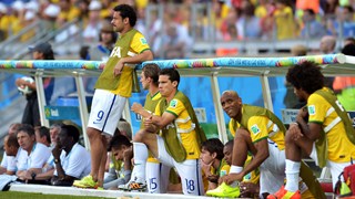 Fred of Brazil looks on from the bench with teammates
