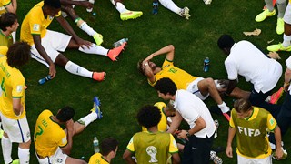 Neymar of Brazil receives treatment as his teammates rest before extra time