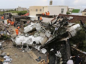 24/7 - Equipe de resgate trabalha em meio aos destroços do avião da TransAsia Airways e das casas que ele atingiu em Penghu, Taiwan (Foto: Reuters/Stringer)