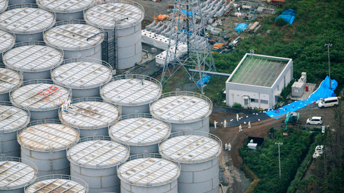 An aerial view shows workers wearing protective suits and masks working atop contaminated water storage tanks at Tokyo Electric Power Co. (TEPCO)'s tsunami-crippled Fukushima Daiichi nuclear power plant in Fukushima (Reuters / Kyodo)