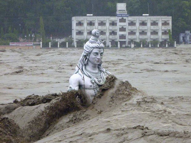 Estátua da deusa hindu Shiva fica quase que totalmente submersa durante inundação do Rio Ganges em Rishikesh (Foto: Reuters)