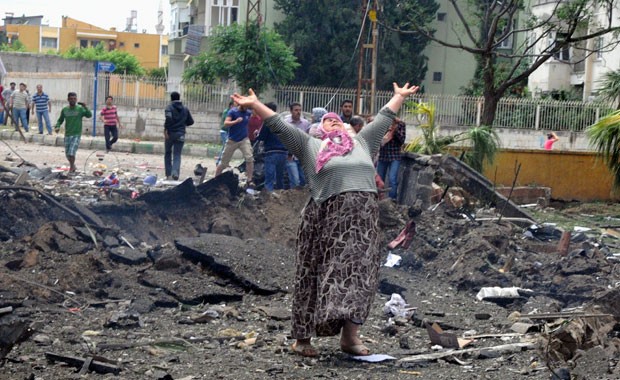 Mulher chora no local da explosão dos carros-bomba em Reyhanli, na Turquia (Foto: AP)