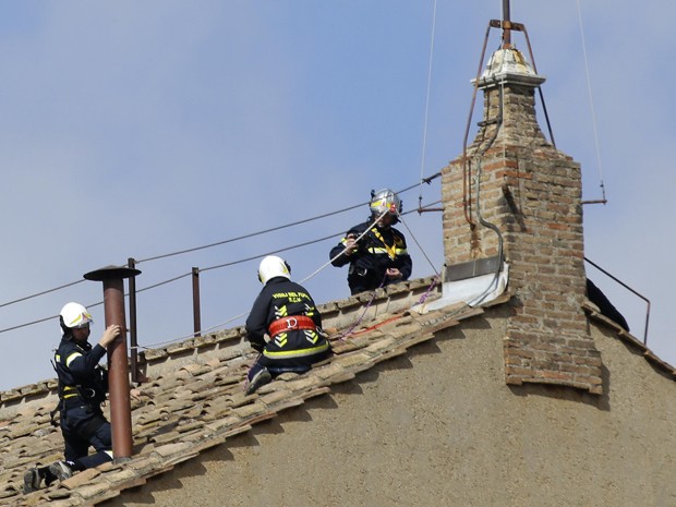 Funcionários do Corpo de Bombeiros trabalham na instalação de uma chaminé no teto da Capela Sistina, no Vaticano, neste sábado (9) (Foto: Max Rossi/Reuters)