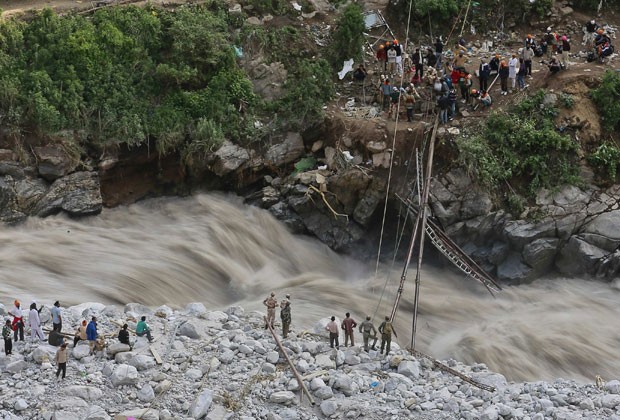 Soldados tentam reparar ponte para pedestres destruída pelas enchentes na Índia neste sábado (22) (Foto: Danish Siddiqui/Reuters)